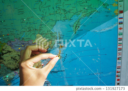 Putting a thumbtack on the place where you are from on a world map Putting a thumbtack on the place where you are from on a world map 131927173
