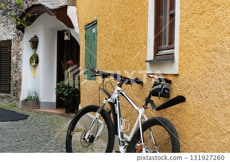 A scene with a bicycle leaning against a yellow painted wall 131927260