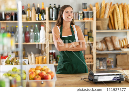 Young woman seller at counter in grocery store 131927877