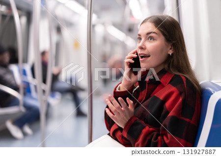 girl sitting in subway car with phone girl sitting in subway car with phone 131927887