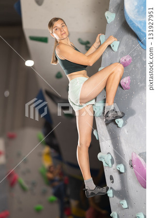 Woman training at bouldering gym without special climbing equipment 131927951
