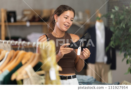 Woman choosing high-heeled shoes in a store Woman choosing high-heeled shoes in a store 131927954