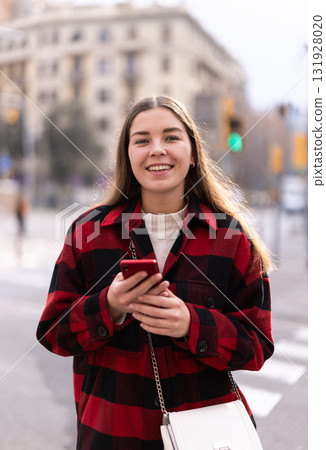 Girl traveler walks through tourist area of European city with phone Girl traveler walks through tourist area of European city with phone 131928020