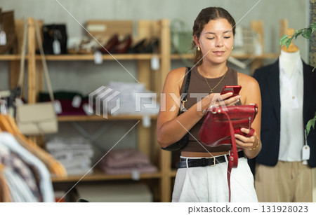 While shopping, girl scans barcode on label of handbag While shopping, girl scans barcode on label of handbag 131928023