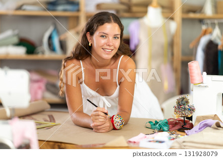 young dressmaker draws a sketch with the help of curved rulers young dressmaker draws a sketch with the help of curved rulers 131928079