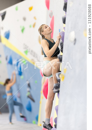 Woman training at bouldering gym without special climbing equipment Woman training at bouldering gym without special climbing equipment 131928088