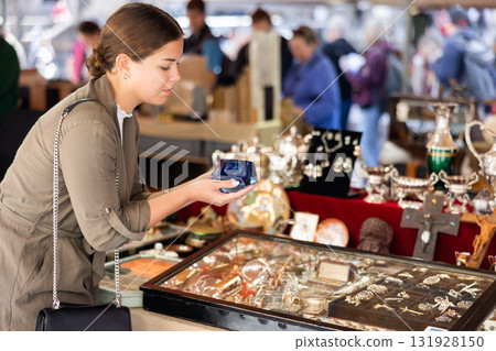 Portrait of smiling young woman choosing vintage goods at flea market 131928150