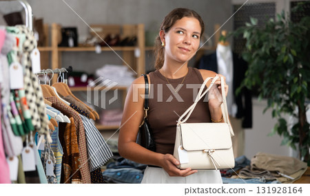 Woman choosing handbags in the store Woman choosing handbags in the store 131928164