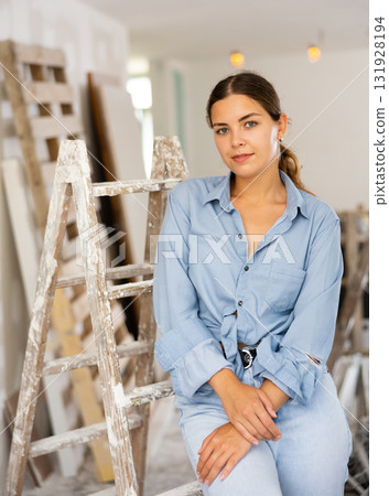 Pretty cottage owner posing in room being renovated Pretty cottage owner posing in room being renovated 131928194
