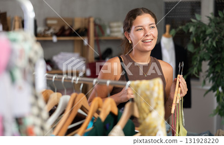 Female customer in store chooses summer clothes. 131928220