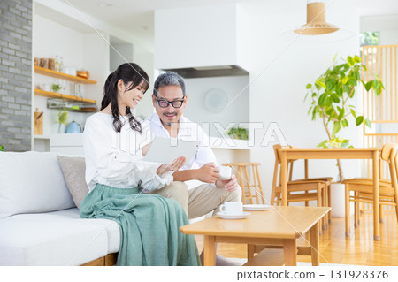 一對中年夫婦邊看電腦邊聊天 一對中年夫婦邊看電腦邊聊天 131928376