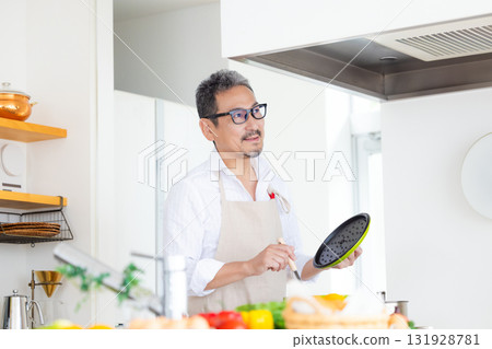 Kitchen Middle-aged man cooking Kitchen Middle-aged man cooking 131928781