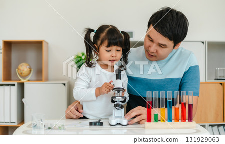 toddler girl scientist looking through a microscope. learning science with father toddler girl scientist looking through a microscope. learning science with father 131929063