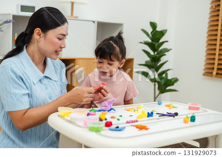 toddler girl with mother sculpting from plasticine at home toddler girl with mother sculpting from plasticine at home 131929073