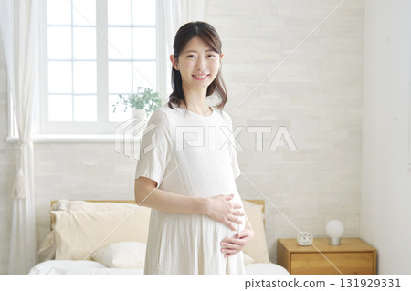 Pregnant woman portrait at home looking at camera 131929331