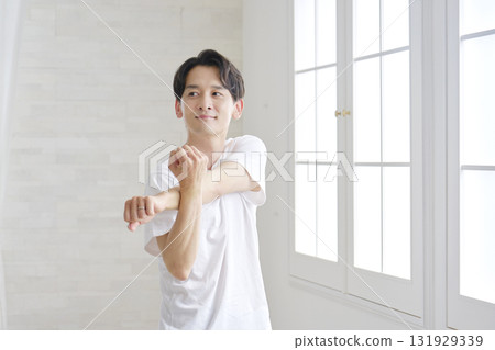 Man stretching his arms at home Man stretching his arms at home 131929339