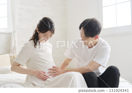 Husband touching his pregnant wife's belly 131929341