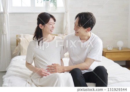 Husband touching his pregnant wife's belly Husband touching his pregnant wife's belly 131929344