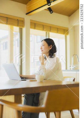 使用個人計算機的婦女在廚房裡 131929782
