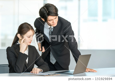A caring businessman helping his subordinate with his work in the office A caring businessman helping his subordinate with his work in the office 131929894