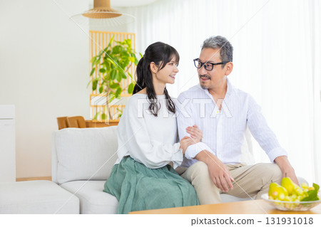 A middle-aged couple sitting on the sofa and chatting A middle-aged couple sitting on the sofa and chatting 131931018
