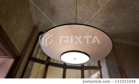 Modern round light fixture hanging in a historic building 131931048