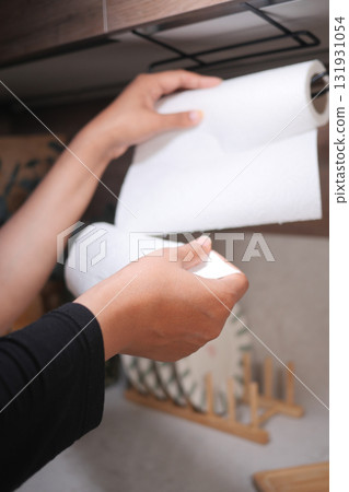Hands using paper towels in a kitchen setting 131931054