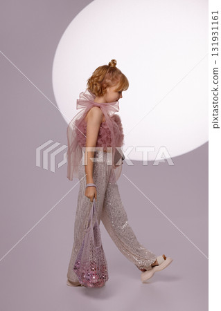 Smiling girl holding Christmas gift and ornaments bag on light background 131931161