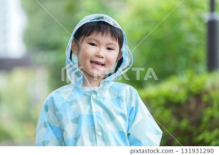 Child wearing a raincoat on a rainy day Child wearing a raincoat on a rainy day 131931290