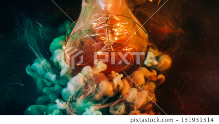Defocused sparkling flow. Light bulb night. Shimmering green orange blob paint. Color particles swirl on garland black abstract background. 131931314
