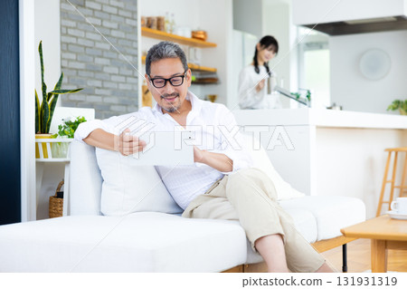 Middle-aged man looking at tablet Middle-aged man looking at tablet 131931319