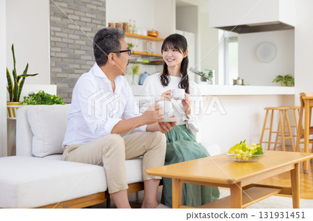 A middle-aged couple sitting on the sofa and chatting 131931451