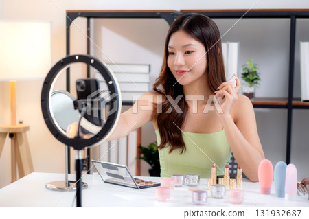 Young asian woman facial spray or serum on social media, content creator. 131932687