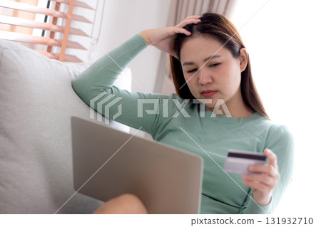 Young asian woman holding credit card or debit card with stress about loan and expense. Young asian woman holding credit card or debit card with stress about loan and expense. 131932710