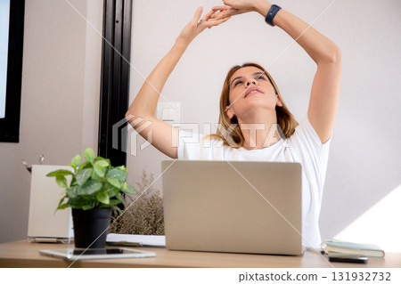 Portrait young caucasian businesswoman taking a break after overworked with stretching arm. 131932732