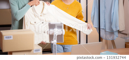Two young asian woman live online clothing store while showing clothing with tablet. Two young asian woman live online clothing store while showing clothing with tablet. 131932744