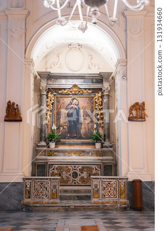 An ornate altar in an Amalfi church features a Virgin Mary painting, gold detailing, marble columns, potted plants, and patterned marble flooring. An ornate altar in an Amalfi church features a Virgin Mary painting, gold detailing, marble columns, potted plants, and patterned marble flooring. 131934660