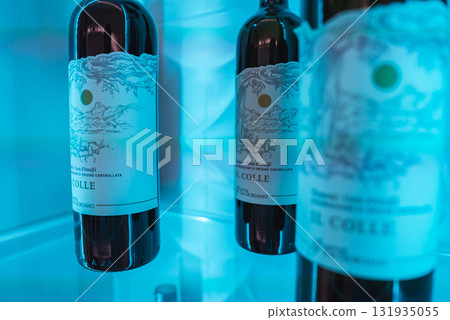 Wine bottles with intricate Amalfi themed labels displayed in a cool toned, illuminated setting, emphasizing their design and premium presentation. Wine bottles with intricate Amalfi themed labels displayed in a cool toned, illuminated setting, emphasizing their design and premium presentation. 131935055