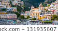 Positano on Italy's Amalfi Coast features stacked buildings, the Church of Santa Maria Assunta, a beach with boats and umbrellas, and lush cliffs. 131935607