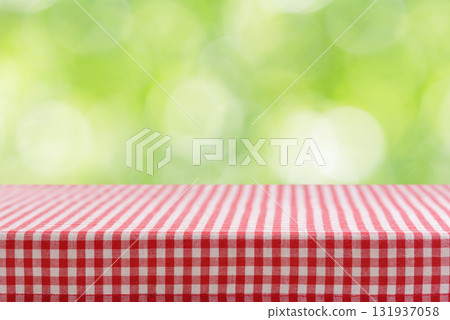 Empty red and white checkered tablecloth for picnic over green background 131937058