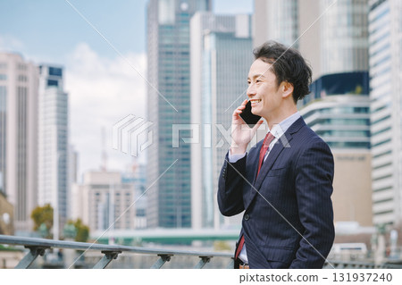 Businessman making a phone call outdoors 131937240