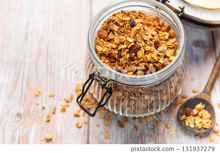 Granola breakfast cereal in glass jar with spoon Granola breakfast cereal in glass jar with spoon 131937279