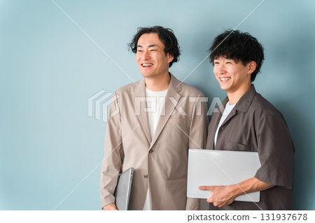 Smiling businessman with a computer (programmer, engineer, system engineer) 131937678