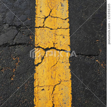 Cracked yellow line on asphalt road surface creating an aged and worn appearance 131938105