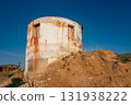 old round building on hill with rusted exterior and clear blue sky in background. closeup. 131938222
