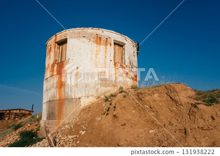 old round building on hill with rusted exterior and clear blue sky in background. closeup. old round building on hill with rusted exterior and clear blue sky in background. closeup. 131938222