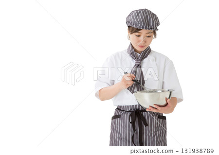 A woman wearing a chef's coat mixing whipped cream in a bowl A woman wearing a chef's coat mixing whipped cream in a bowl 131938789