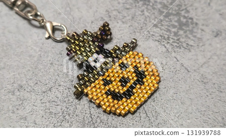 Handcrafted pumpkin-shaped keychain made of orange seed beads and glass beads Handcrafted pumpkin-shaped keychain made of orange seed beads and glass beads 131939788
