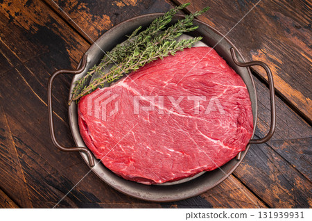 Premium raw rump or top sirloin beef steak on a tray, ready to be seasoned and grilled to perfection. wooden background. top view 131939931