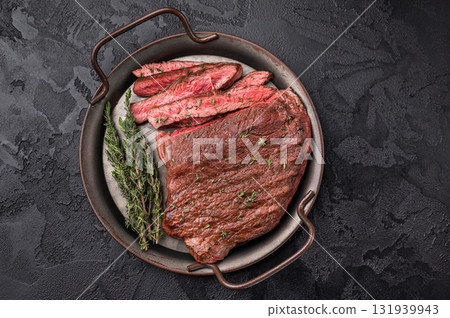 Succulent grilled top sirloin steak, cooked to perfection and drizzled with a rich sauce for an unforgettable dining experience. black background. top view Succulent grilled top sirloin steak, cooked to perfection and drizzled with a rich sauce for an unforgettable dining experience. black background. top view 131939943
